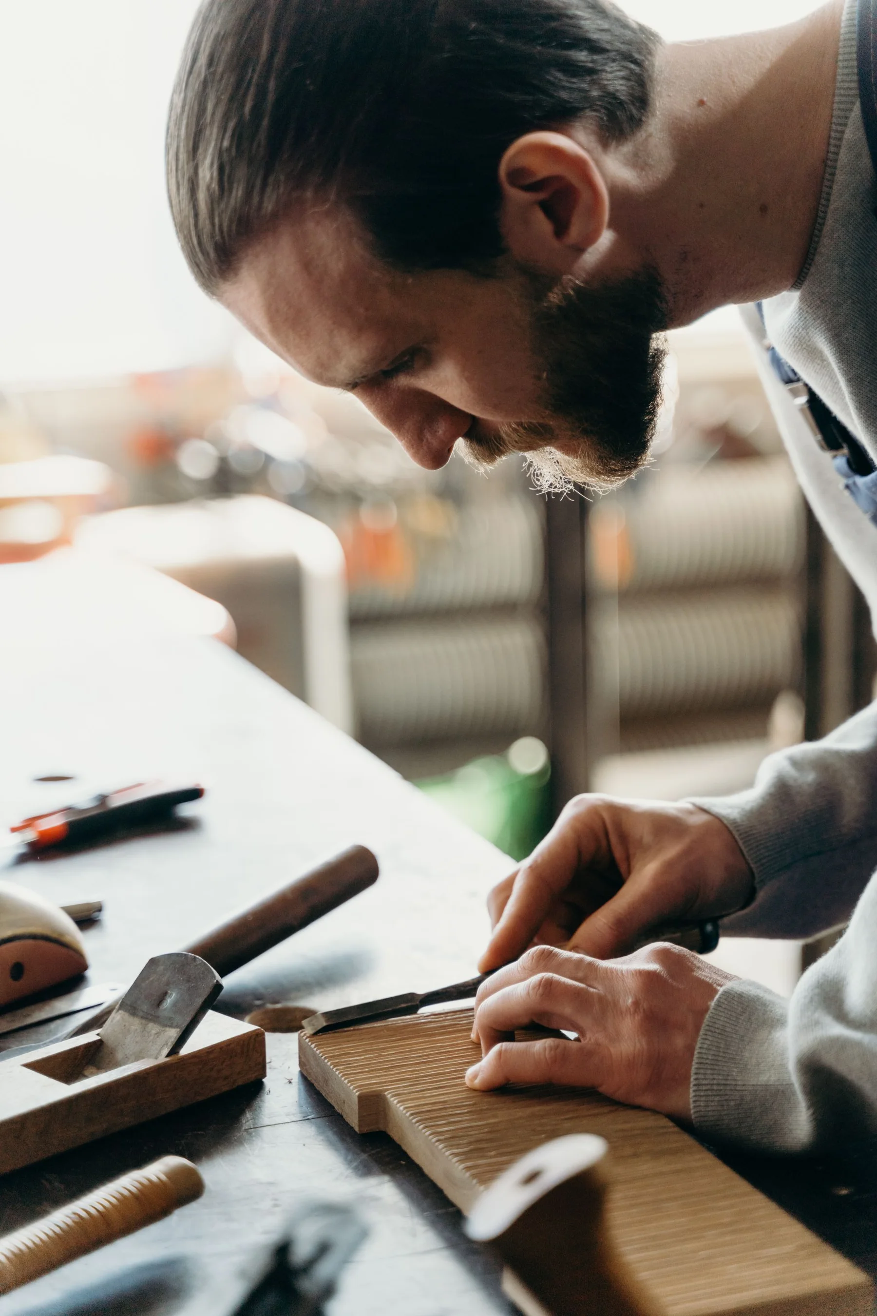 A carpenter carefully shaping wood in a workshop